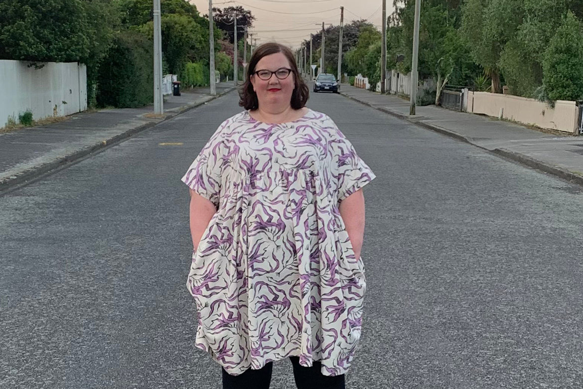 Person standing in a road wearing a kelp printed dress