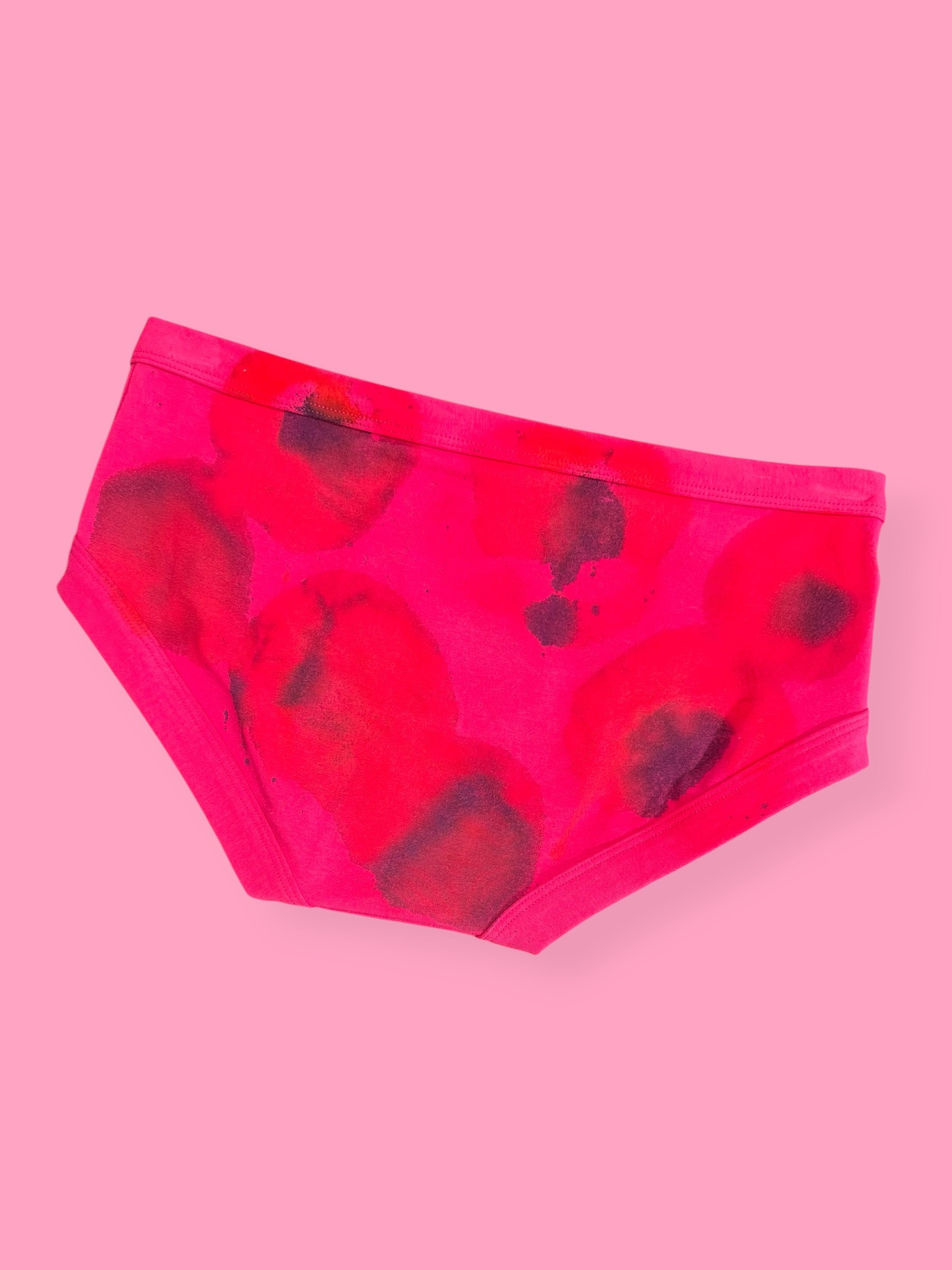 Pink splodgy printed pants on a pink background
