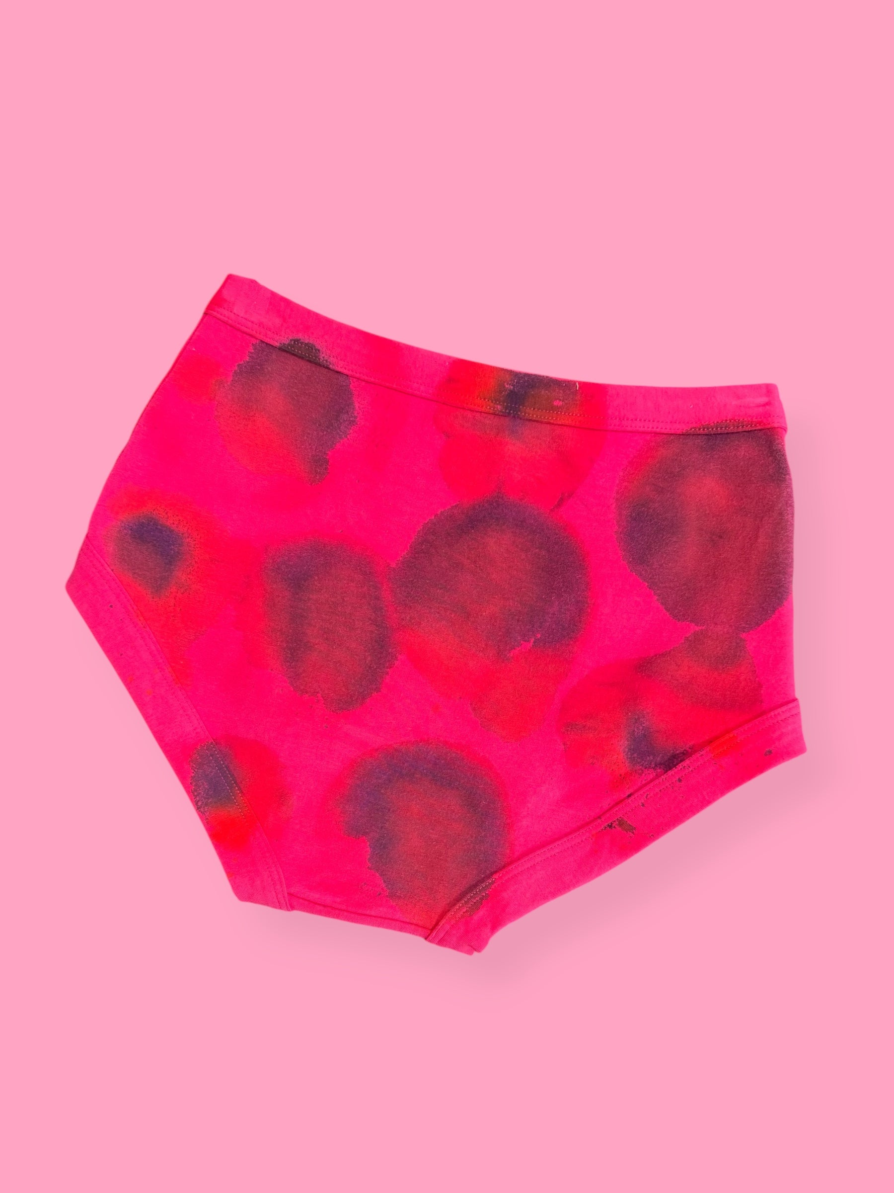 Pink underwear with red and black abstract pattern on a pink background