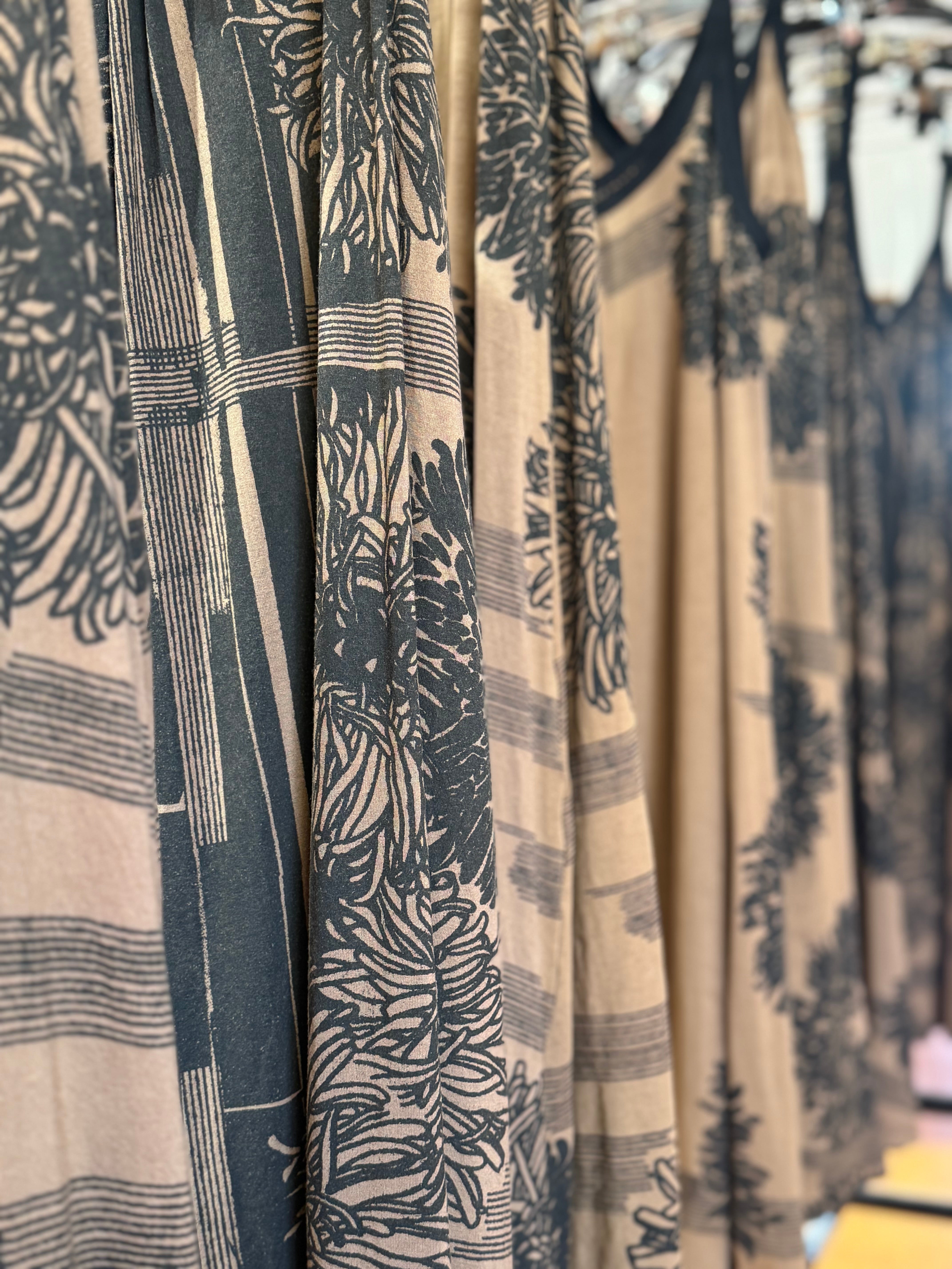 Close-up of patterned fabric with black and beige design on a clothing rack.
