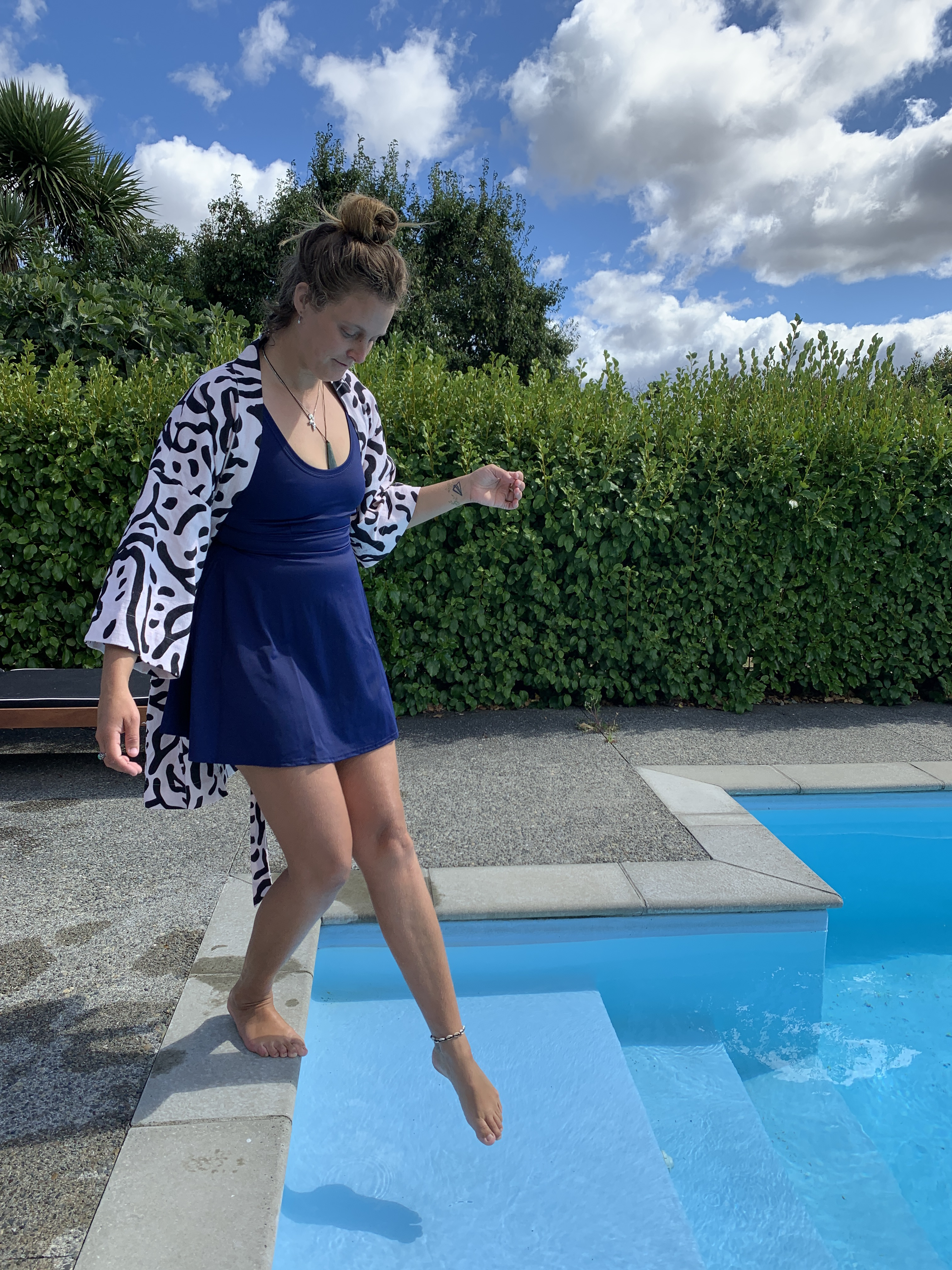 Flared Swim Dress on person dipping toes in a pool