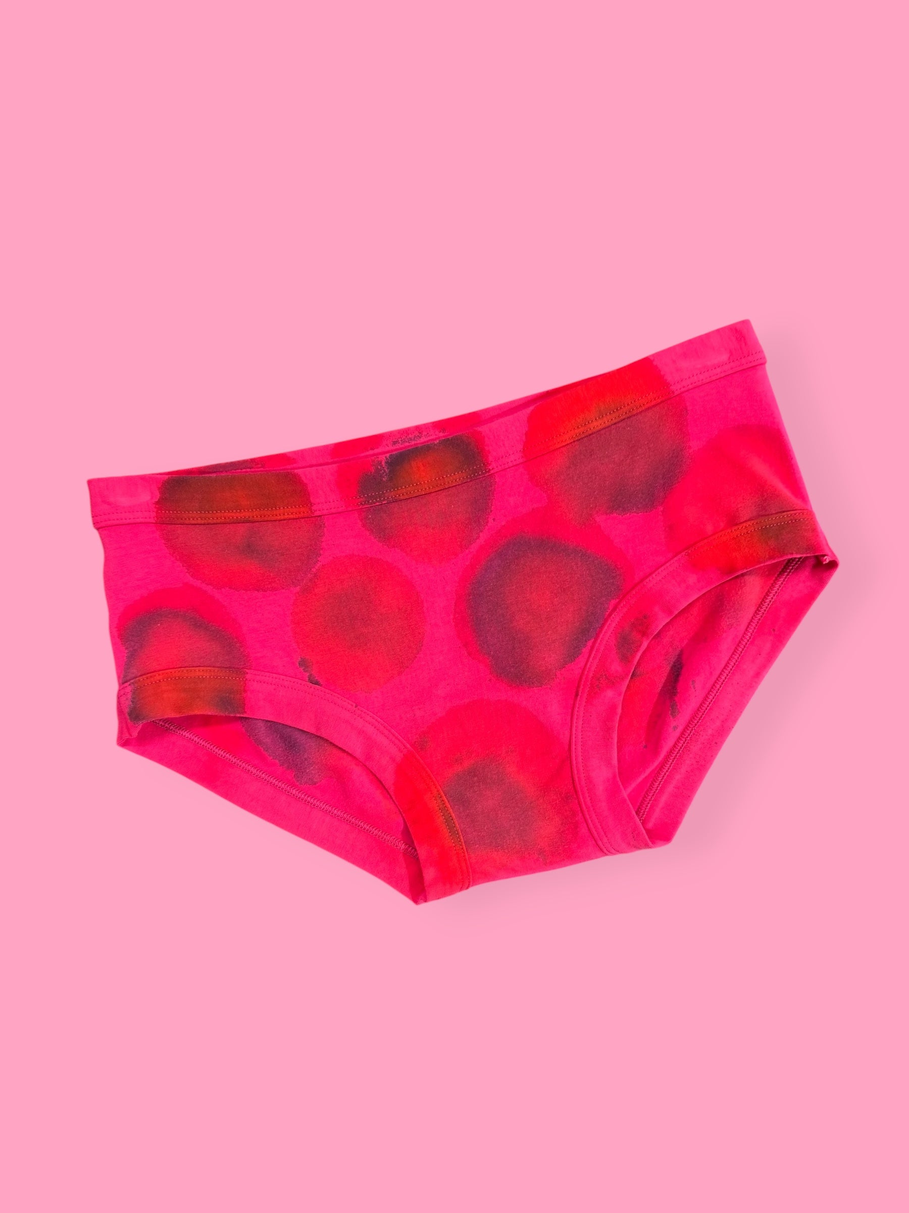 Pink splodgy printed pants on a pink background