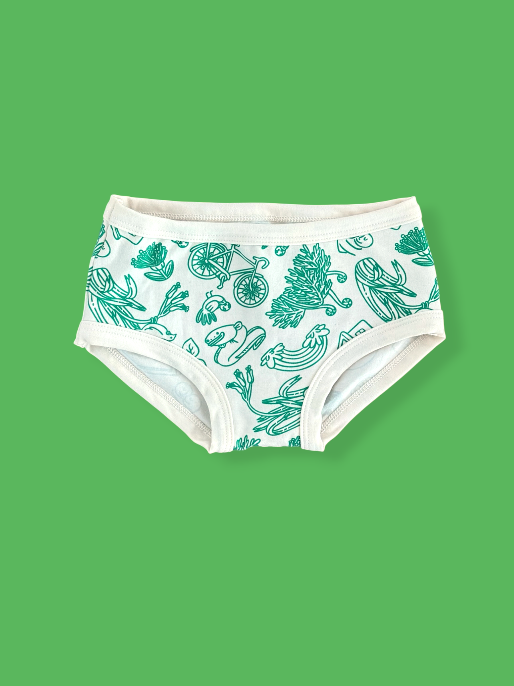 White low-rise briefs with a green botanical and bicycle pattern, shown against a solid green background.