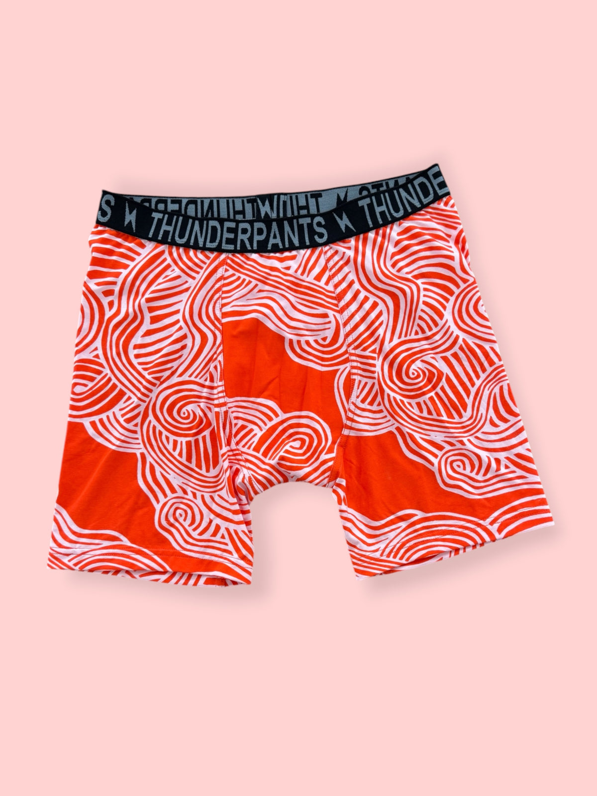 Orange Zen printed everyboxers laid flat on a pink background
