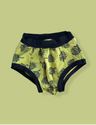 Yellow baby bloomers with black floral pattern on a light green background