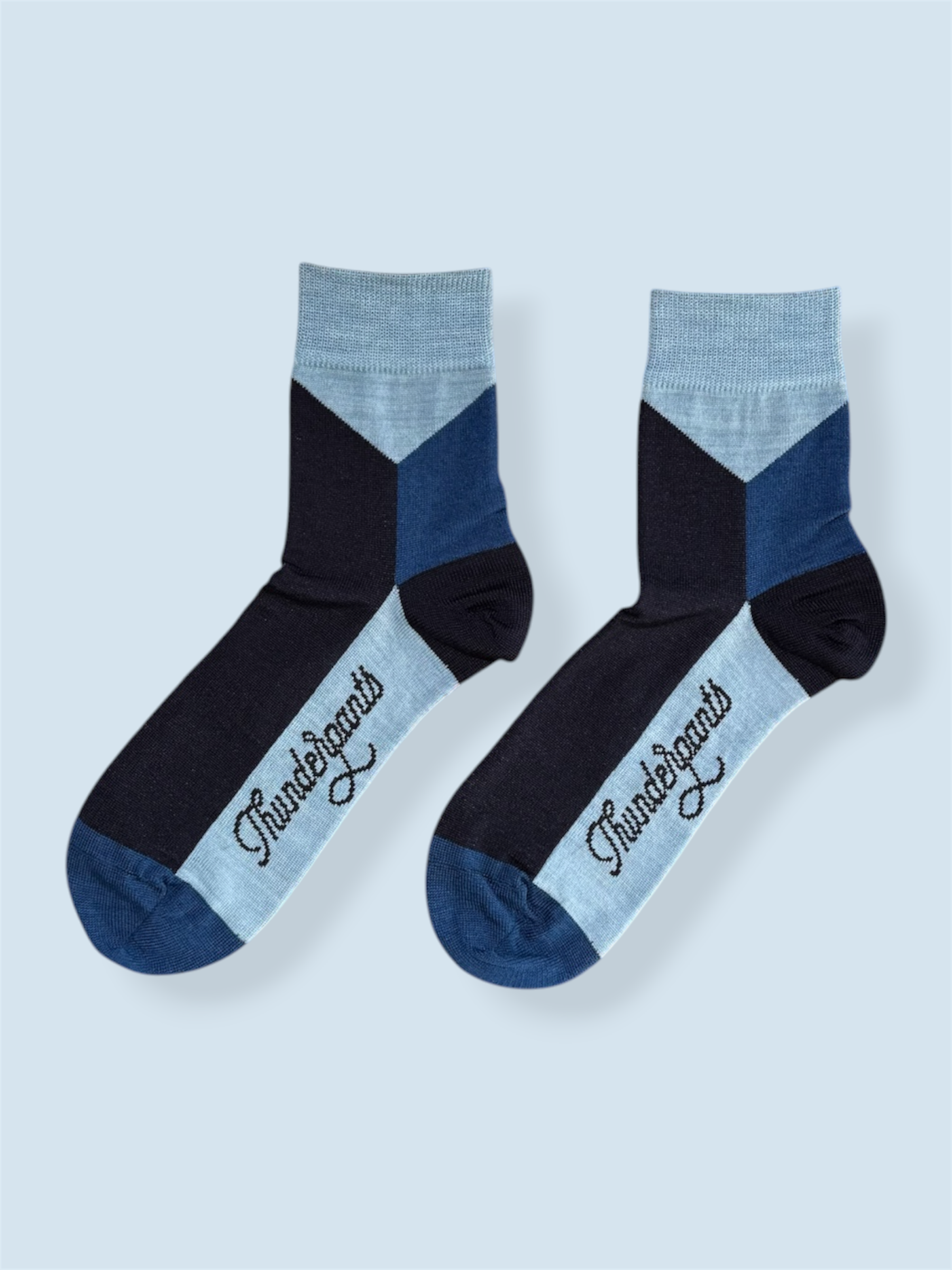 Pair of black and blue socks with 'Thunderbolts' branding on a light gray background