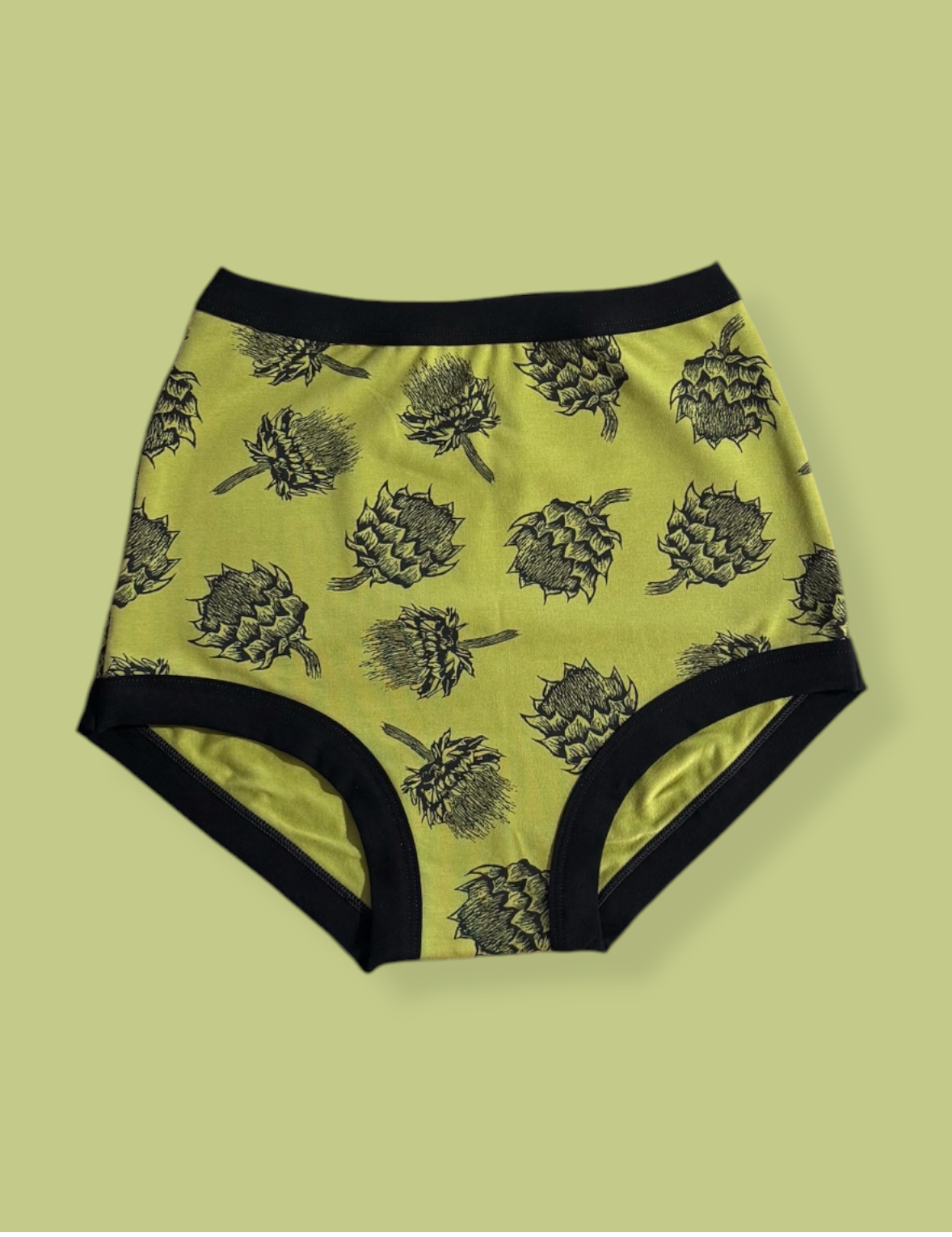High-waisted underwear with black artichoke pattern on a light green background