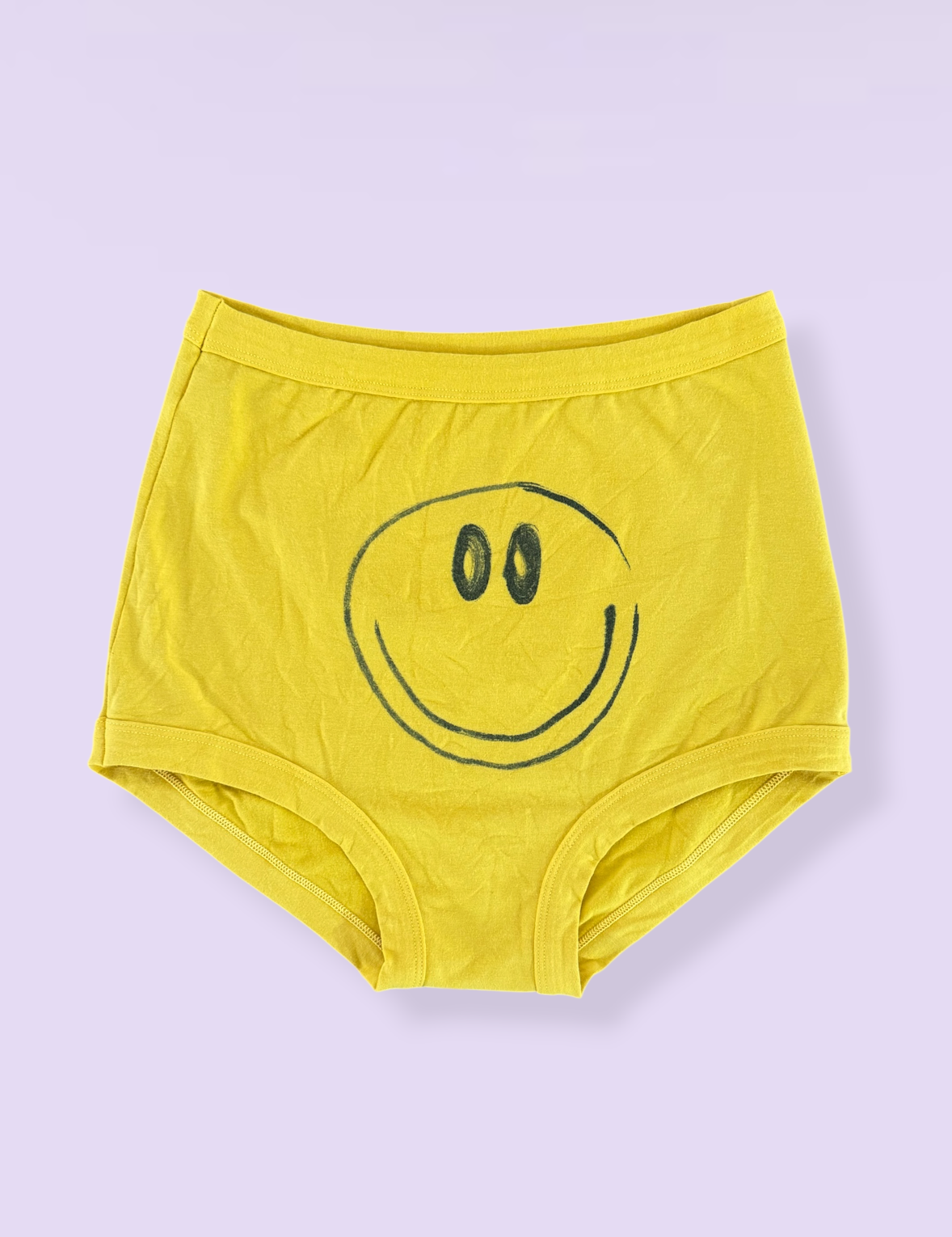 Yellow underwear with a smiley face design on a light purple background