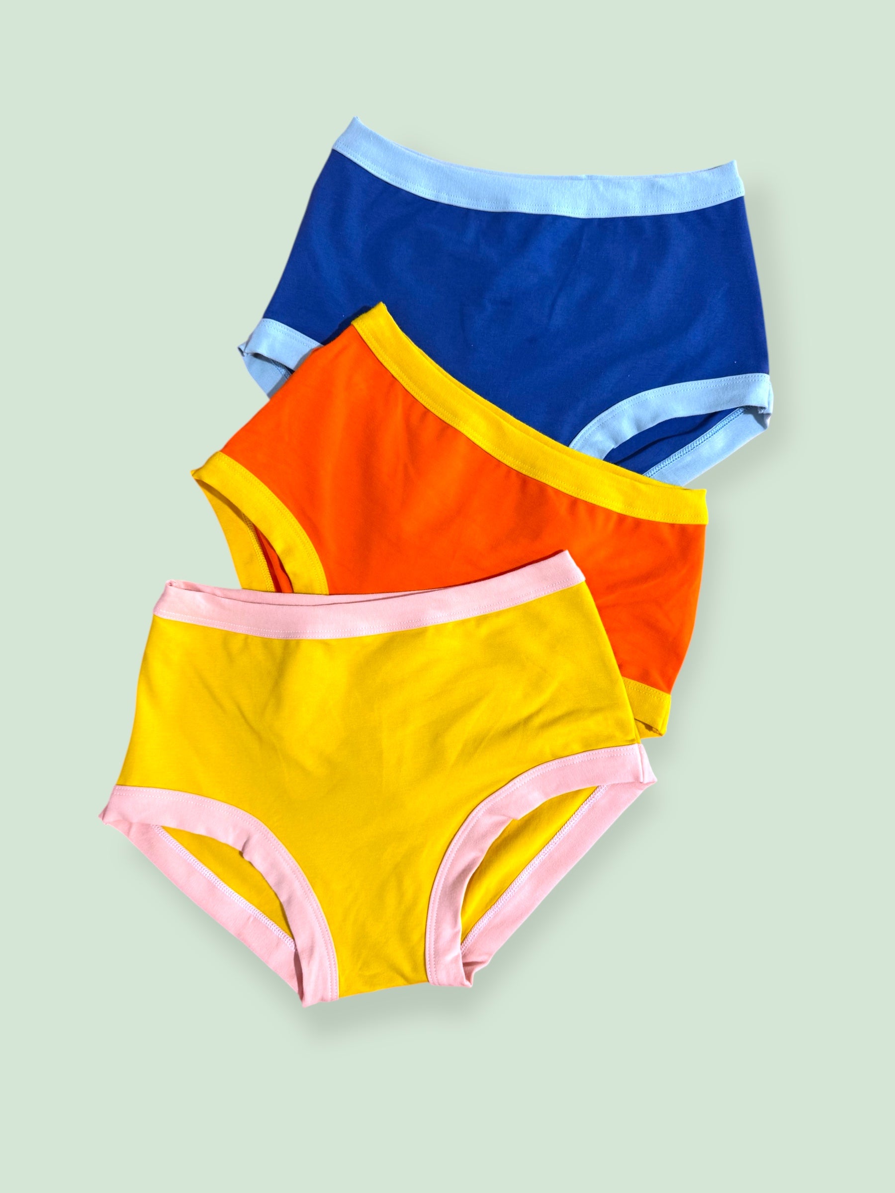 three bright colour blocked Thunderpants laid flat