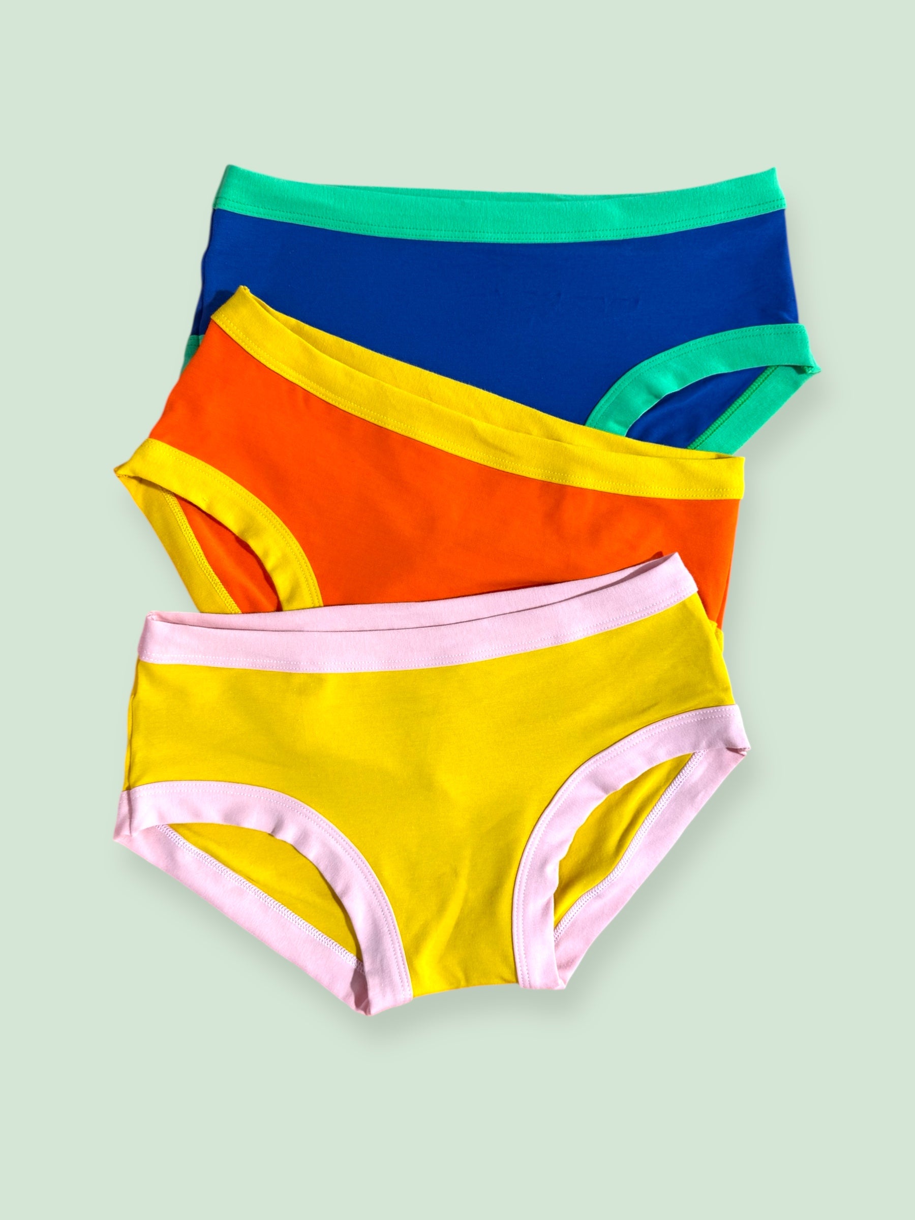 three bright colour blocked Thunderpants laid flat