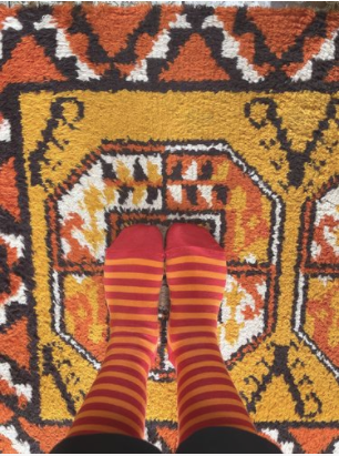 Socks on two feet standing on a rug